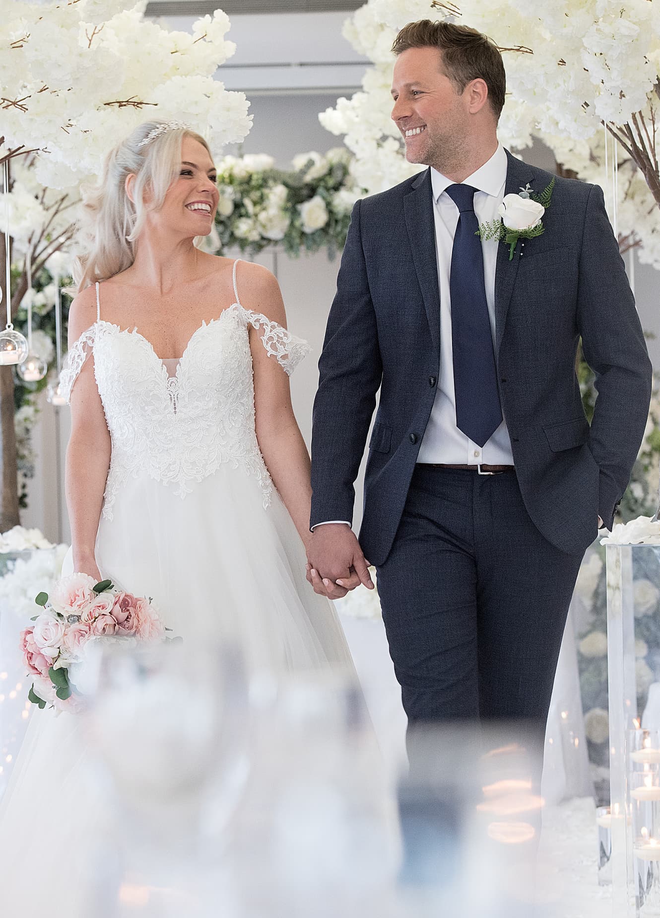 Couple holding hands walking down the aisle on their wedding day