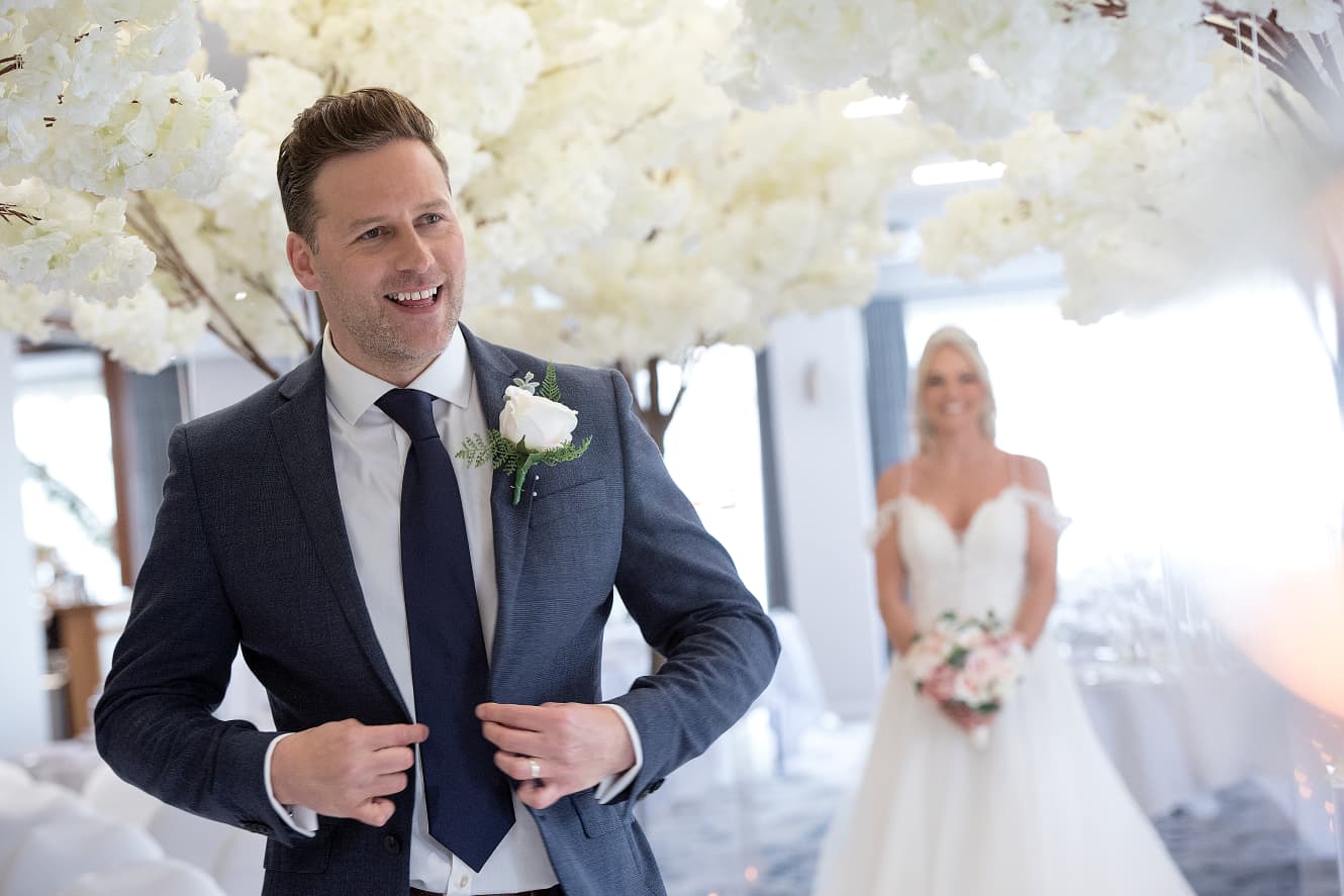 Couple celebrating their wedding with a glass of fizzy wine on a golf caddy